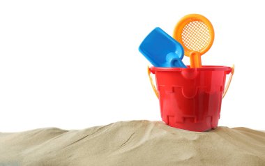 Kum yığını üzerinde kürek olan plastik bir oyuncak.