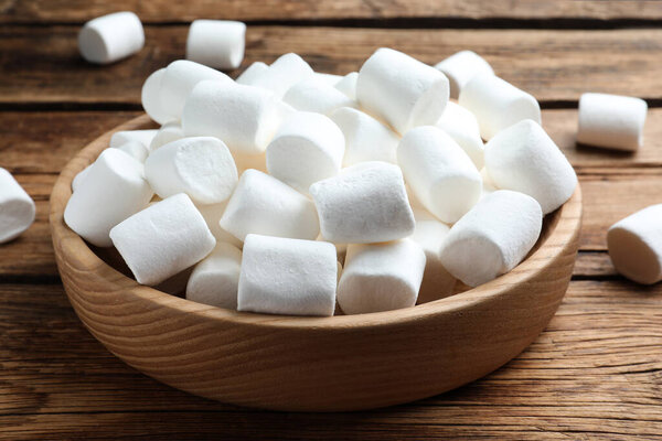 Delicious puffy marshmallows on wooden table, closeup
