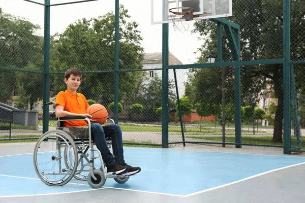 Niepełnosprawny Nastolatek Wózku Inwalidzkim Piłką Koszykówki Boisku — Zdjęcie stockowe