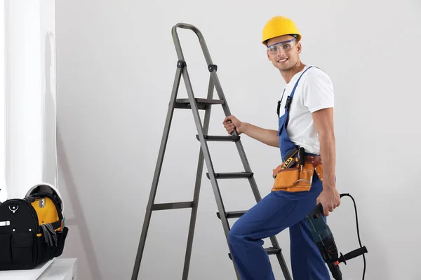 Werknemer Met Elektrische Boor Ladder Binnen — Stockfoto