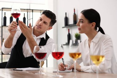 Sommelier 'ler kapalı bir masada farklı türde şarap tadıyorlar.