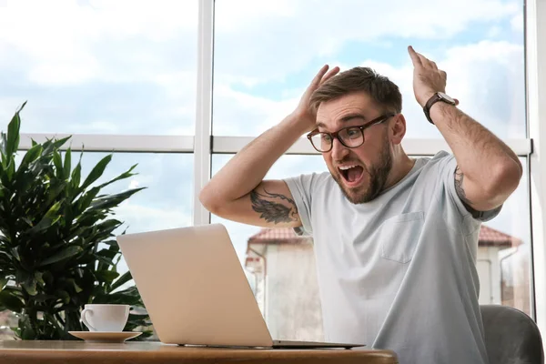 在家里用笔记本电脑参加网上拍卖的情绪化男人 — 图库照片