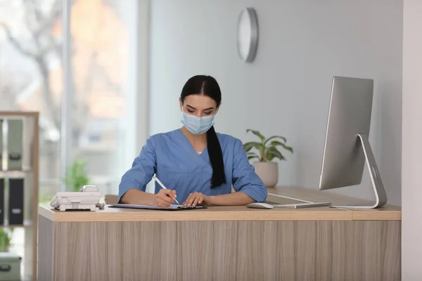 Recepcionista Con Máscara Protectora Trabajando Encimera Hospital — Foto de Stock