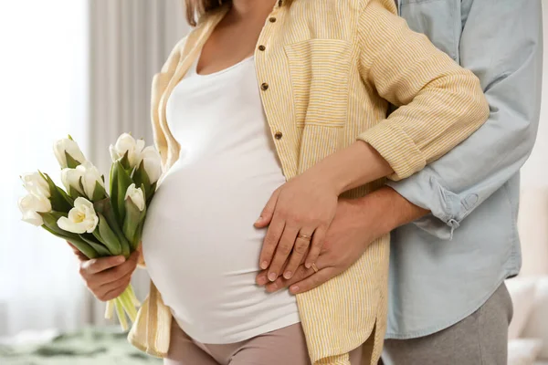 Jonge Zwangere Vrouw Met Bloemen Haar Man Binnen Close — Stockfoto