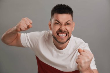 Gri arka planda kızgın bir adam. Nefret konsepti
