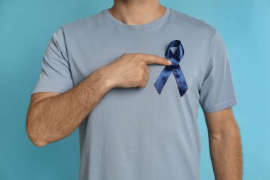 Açık mavi arka planda kurdeleli adam, yakın plan. Üroloji kanseri farkındalığı