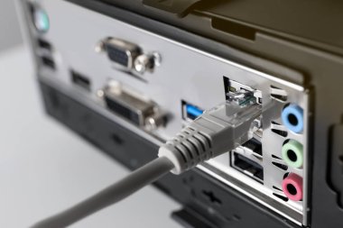 Masadaki bilgisayar sistemi ünitesine kablo bağlı, yakın plan. İnternet iletişimi