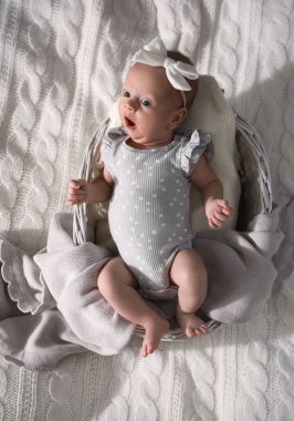 Sevimli yeni doğmuş bebek sepetin içinde, yatakta, en üstte.