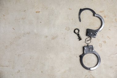 Klasik zincirli kelepçeler. Anahtarı açık masada, düz yerde. Metin için boşluk