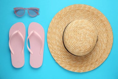 Turkuaz arka planda hasır şapkalı düz konum