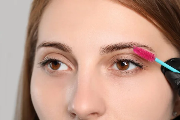 Beautician Brushing Woman Eyebrows Tinting Grey Background Closeup — Stock Photo, Image