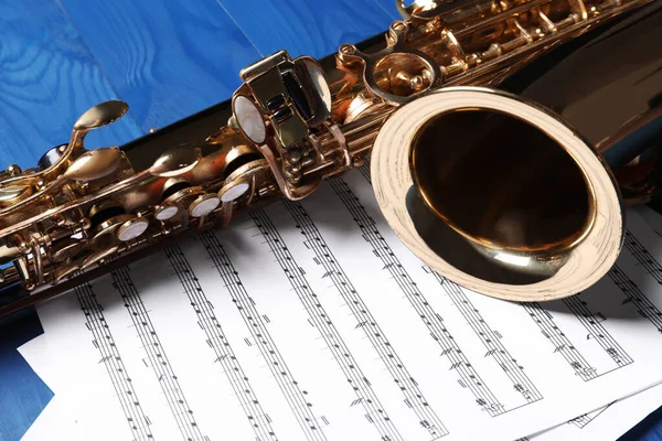 Piękny Saksofon Notatki Niebieskim Drewnianym Tle Zbliżenie — Zdjęcie stockowe