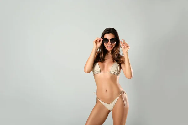 Mooie Vrouw Stijlvolle Bikini Zonnebril Lichtgrijze Achtergrond Ruimte Voor Tekst — Stockfoto
