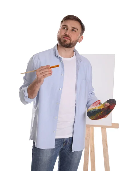白い背景にイーゼルの近くの絵画ツールを持つ男 若手作家 — ストック写真