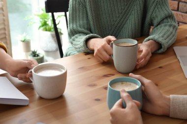 Kafede elinde kahve bardakları olan kadınlar, yakın plan.