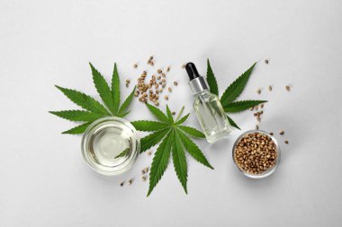 Hafif arkaplanda CBD yağı veya THC teni ve kenevir yaprakları ile düz bir bileşim yatıyordu