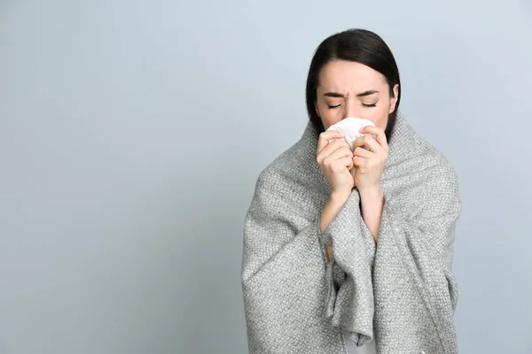 Jeune Femme Avec Couverture Souffrant Écoulement Nasal Sur Fond Gris — Photo