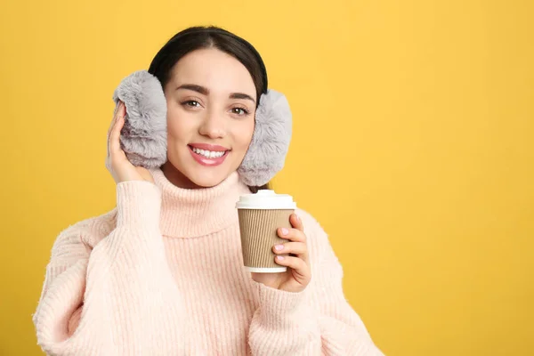 Hermosa Mujer Joven Orejeras Con Taza Bebida Sobre Fondo Amarillo —  Fotos de Stock