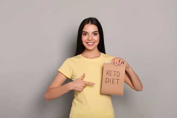 Mujer Feliz Sosteniendo Cuaderno Con Palabras Keto Dieta Sobre Fondo — Foto de Stock