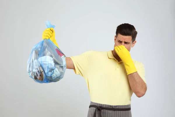 Άντρας Κρατώντας Πλήρη Σακούλα Σκουπιδιών Στο Φως Φόντο — Φωτογραφία Αρχείου