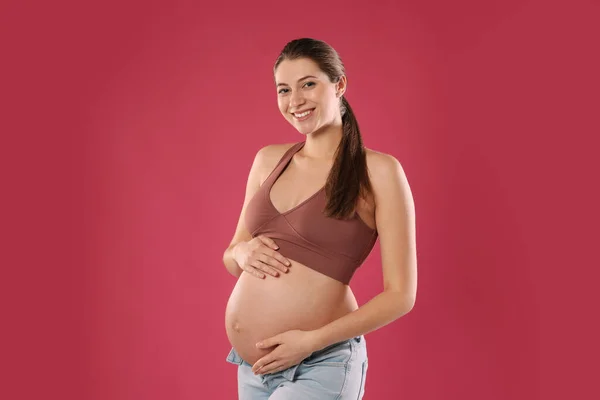 Ευτυχισμένη Νεαρή Έγκυος Γυναίκα Κόκκινο Φόντο — Φωτογραφία Αρχείου