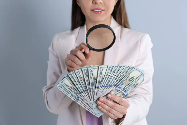 Expert Authenticeren 100 Dollar Bankbiljetten Met Vergrootglas Lichtgrijze Achtergrond Close — Stockfoto