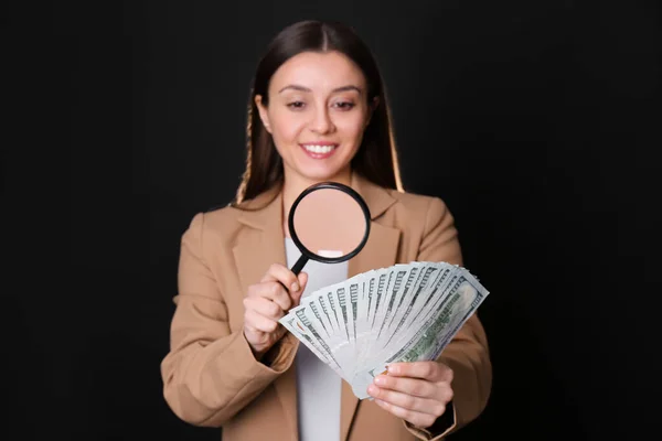 Expert Authenticeren 100 Dollar Bankbiljetten Met Vergrootglas Tegen Zwarte Achtergrond — Stockfoto