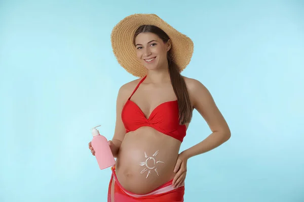Jonge Zwangere Vrouw Met Zonnebrandcrème Lichtblauwe Achtergrond — Stockfoto