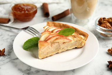 Lezzetli elmalı turta dilimi beyaz mermer masada.