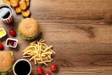 Düz kompozisyon ve ahşap masada lezzetli fast food menüsü. Metin için boşluk