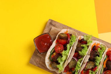 Sarı masada servis edilen bir sürü lezzetli vejetaryen taco.
