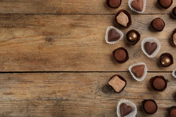 木製のテーブルの上に別のおいしいチョコレートキャンディー フラットレイアウト テキストのスペース — ストック写真