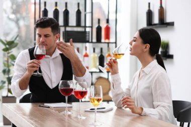Sommelier 'ler kapalı bir masada farklı türde şarap tadıyorlar.
