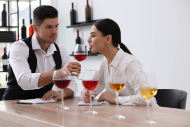Sommelier 'ler kapalı bir masada farklı türde şarap tadıyorlar.