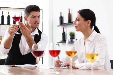 Sommelier 'ler kapalı bir masada farklı türde şarap tadıyorlar.