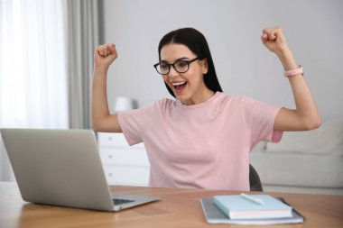 Evde dizüstü bilgisayar kullanarak online müzayedeye katılan duygusal kadın.