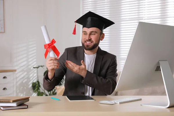 オフィスの職場で卒業帽子と卒業証書を持つ幸せな学生 — ストック写真