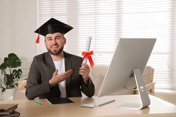 オフィスの職場で卒業帽子と卒業証書を持つ幸せな学生 — ストック写真
