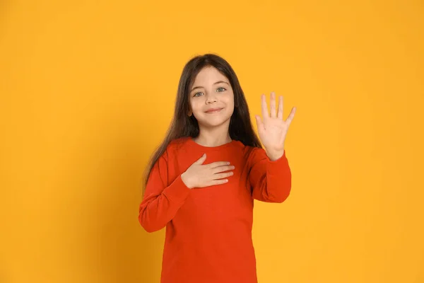 Glückliches Kleines Mädchen Winkt Hallo Sagen Auf Gelbem Hintergrund — Stockfoto