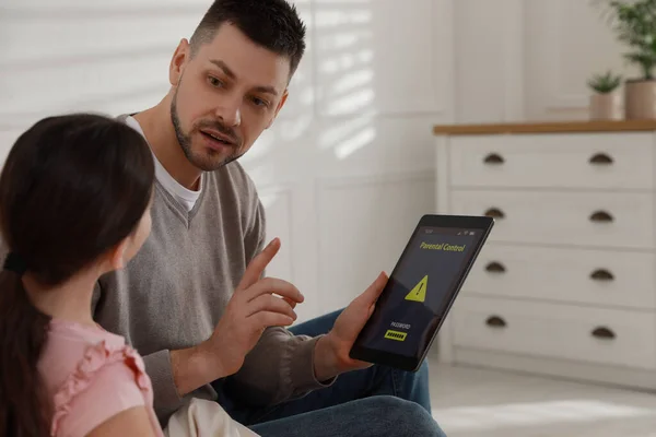 Dad installing parental control on tablet at home. Child safety