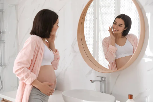 Jovem Grávida Aplicando Produto Cosmético Rosto Banheiro — Fotografia de Stock