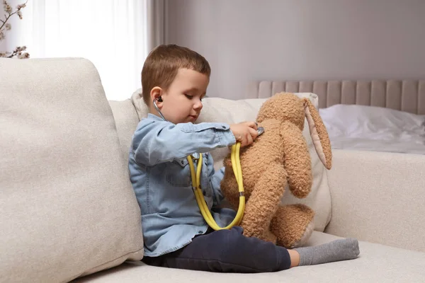 Söt Liten Pojke Leker Med Stetoskop Och Leksak Kanin Hemma — Stockfoto