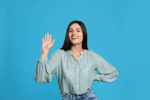 Mujer Feliz Saludando Con Mano Sobre Fondo Azul Claro — Foto de Stock