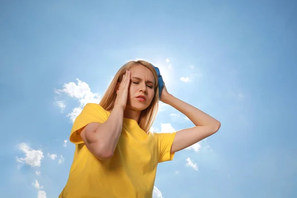 Woman with cold pack suffering from heat stroke outdoors