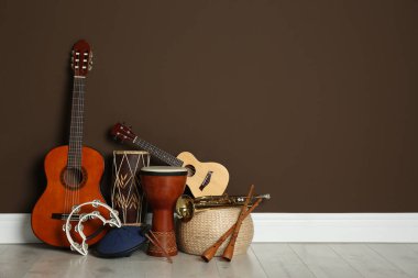 Kahverengi duvarın yanında farklı müzik aletleri seti, metin için boşluk