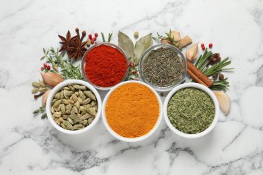 Beyaz mermer masa üzerinde farklı doğal baharat ve otlarla düz bir kompozisyon sergiliyordu.