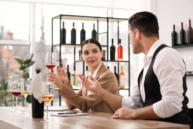 Sommelier 'ler kapalı bir masada farklı türde şarap tadıyorlar.