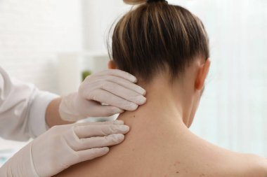 Dermatolog klinikte hastanın doğum lekesini inceliyor.