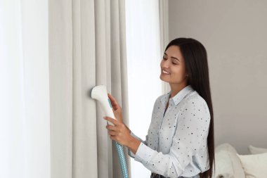 Evdeki pencerenin yanında buharlı perde olan bir kadın. Metin için boşluk