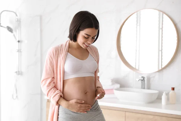 Jonge Zwangere Vrouw Aanbrengen Van Cosmetische Product Buik Badkamer — Stockfoto